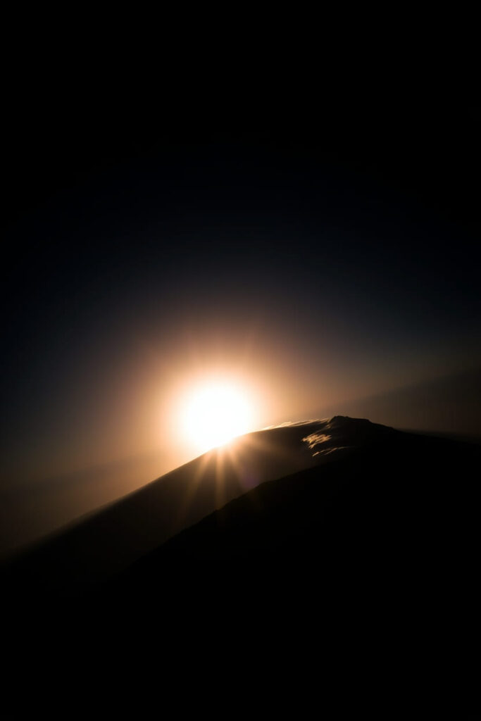 High angle perspective, chiaroscuro lighting, Mount Kilimanjaro, Tanzania. Strong contrasts, deep shadows, elevated view showcasing sunrise over Africa’s rooftop